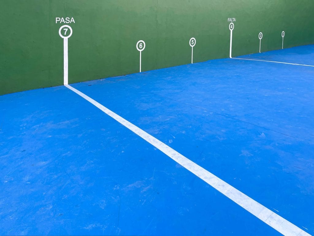white lines marks with numbers on the green wall and blue floor